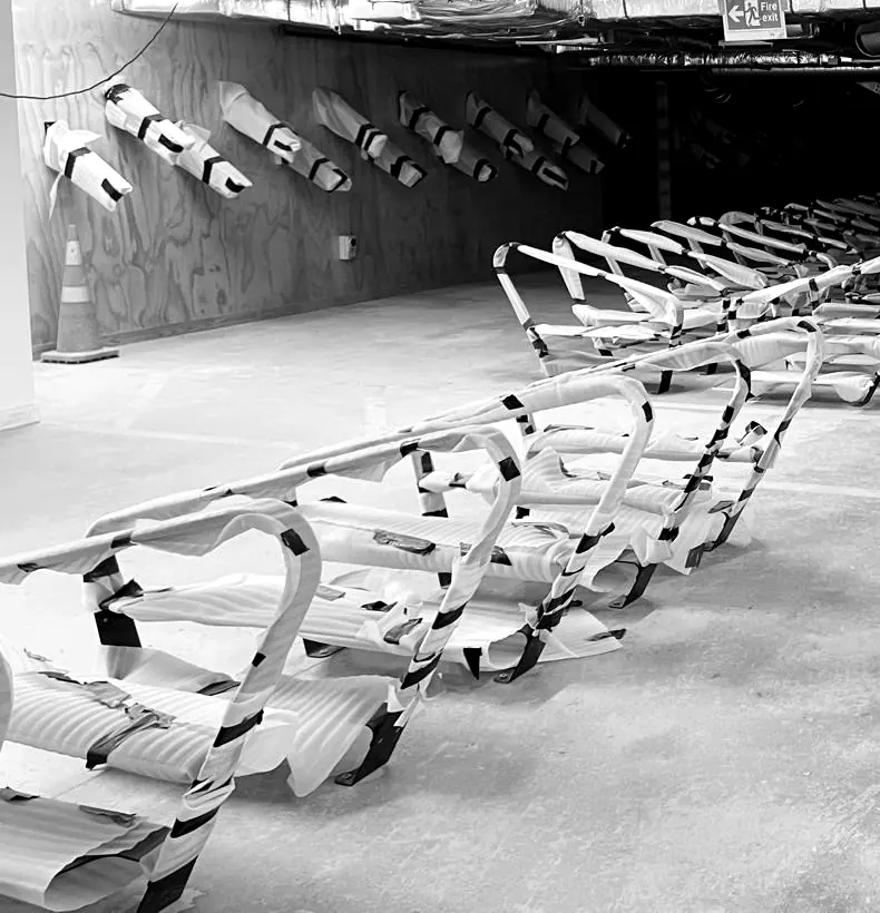 Foam-wrapped bike racks laid out in a basement, ready for installation